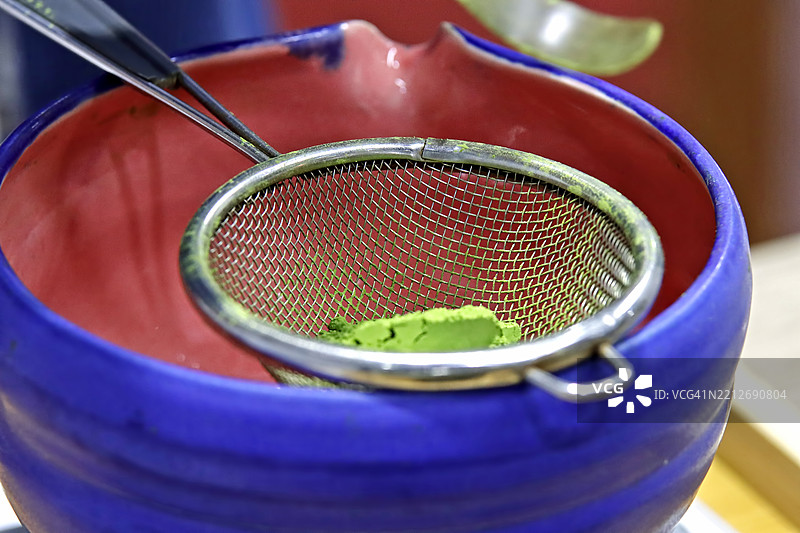 用于过滤或研磨绿茶粉的筛子放在陶瓷杯中图片素材