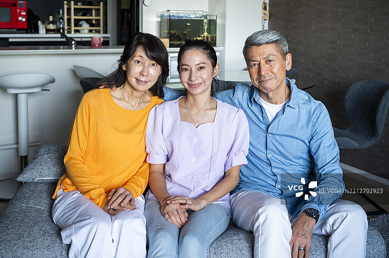 三代日本家庭坐在家里的沙发上图片素材