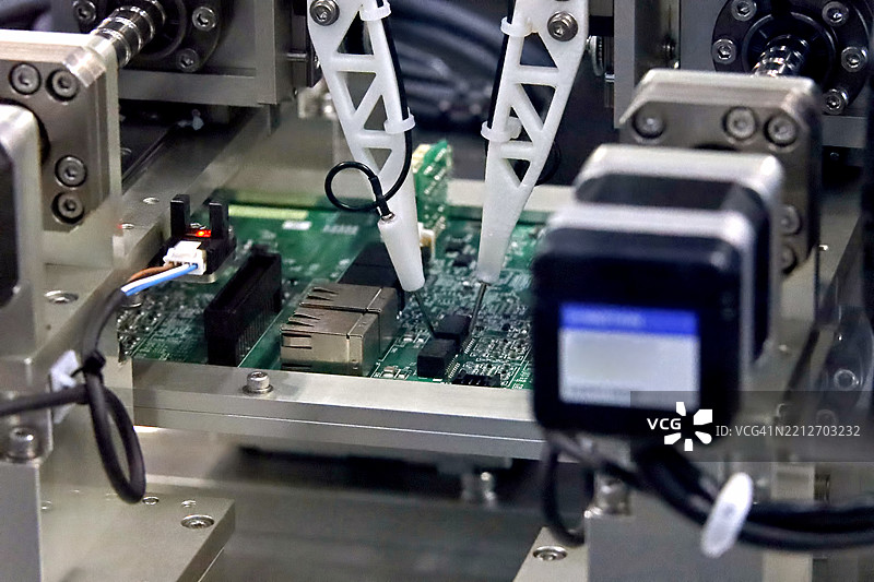 在工厂中用于焊接或焊接零件的印刷电路板组装机器的自动化机器人。图片素材