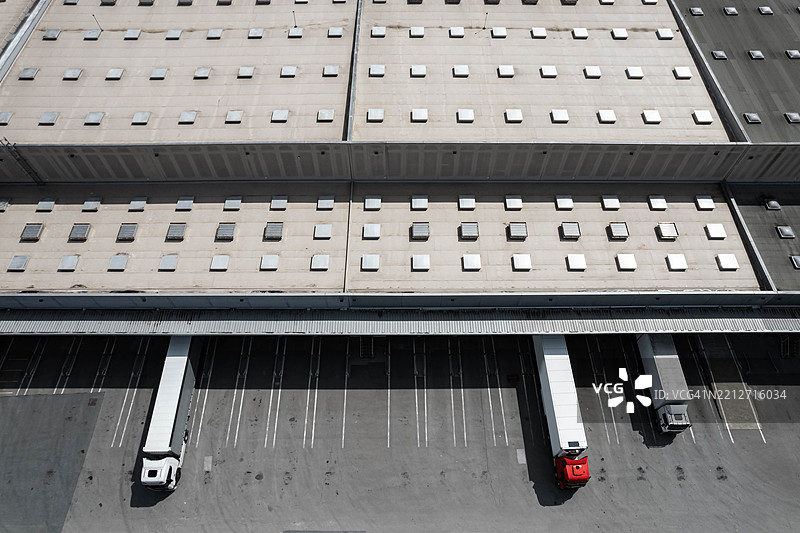 大型工业物流中心的鸟瞰图，多个货运卡车停靠在装卸区。图片素材