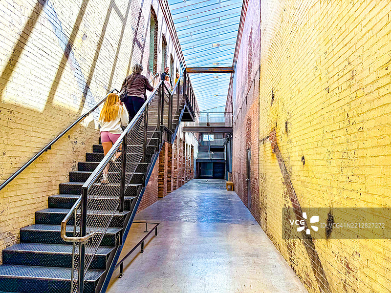人们在北亚当斯的马斯莫卡建筑间走上台阶图片素材