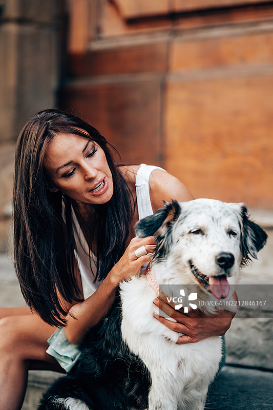 女人在抚摸她可爱的狗狗图片素材