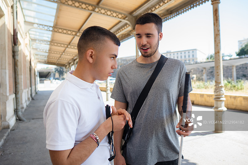 两个年轻的盲人朋友在火车站交谈图片素材