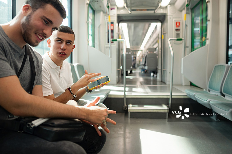 两位盲人朋友在地铁上使用智能手机图片素材