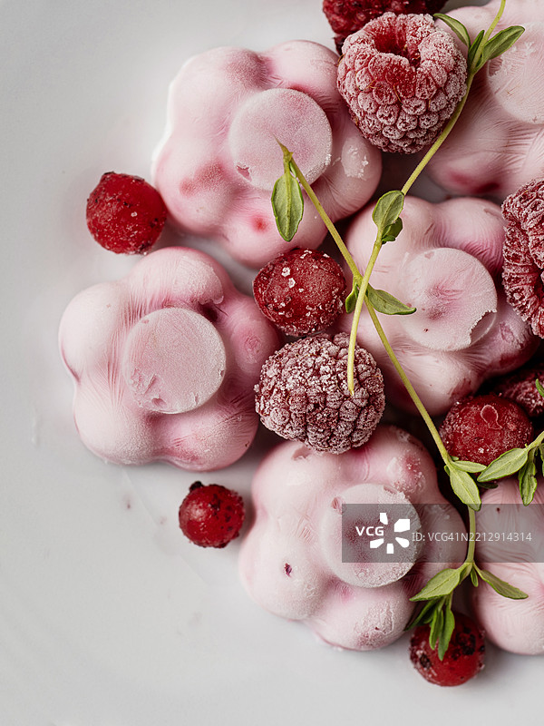 浆果冰沙冰淇淋。自制冰淇淋。自制的覆盆子酸奶，花朵形状。盘子上的甜浆果冰沙。图片素材