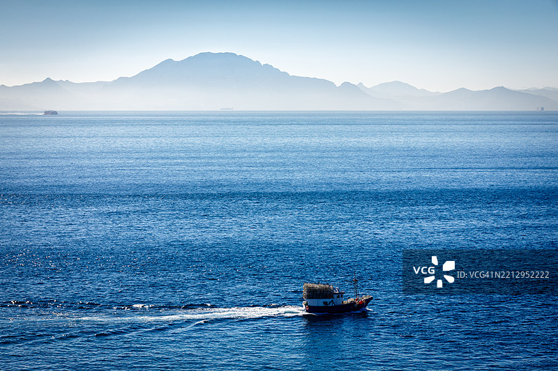 渔船在直布罗陀海岸航行，远处可见北非。图片素材