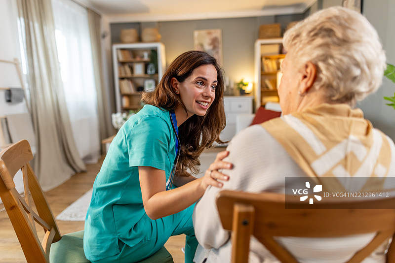 关心的护士在家庭环境中与老年女性互动图片素材