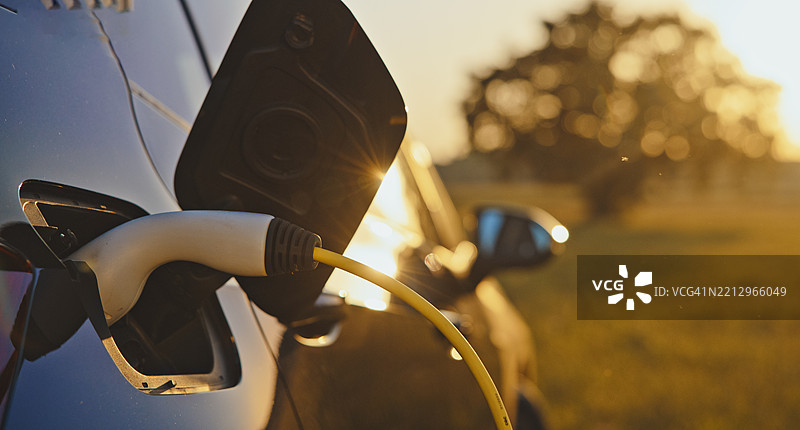 电动插头与汽车充电口的特写，展示现代电动车充电技术图片素材