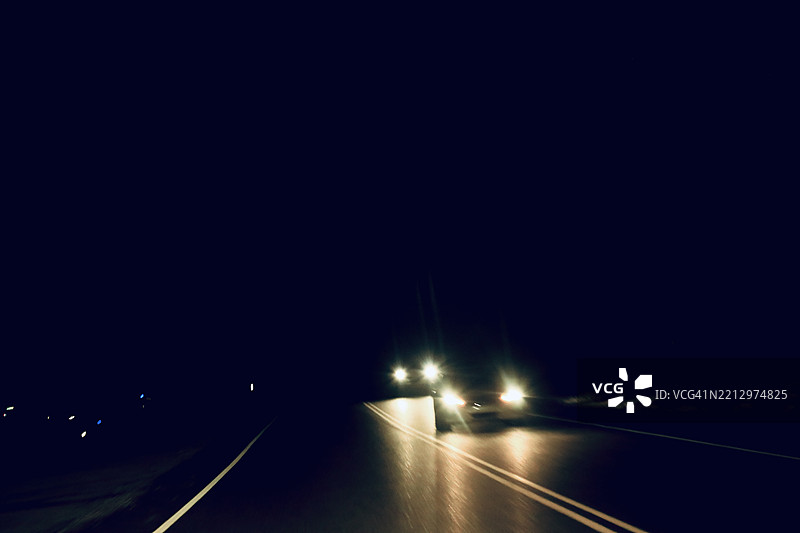 夜晚黑暗的街道上有迎面而来的车辆图片素材