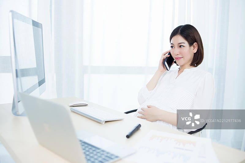 怀孕的女商人在办公室工作图片素材