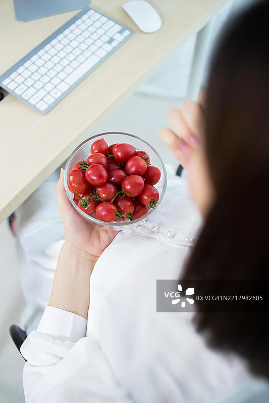 孕妇在工作时吃樱桃番茄图片素材