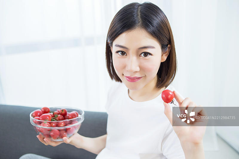 孕妇在吃樱桃番茄图片素材