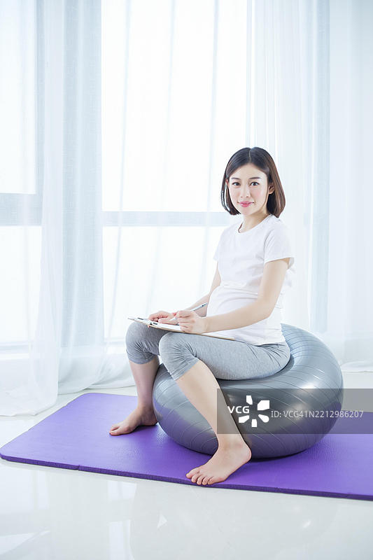 亚洲孕妇在家做瑜伽图片素材