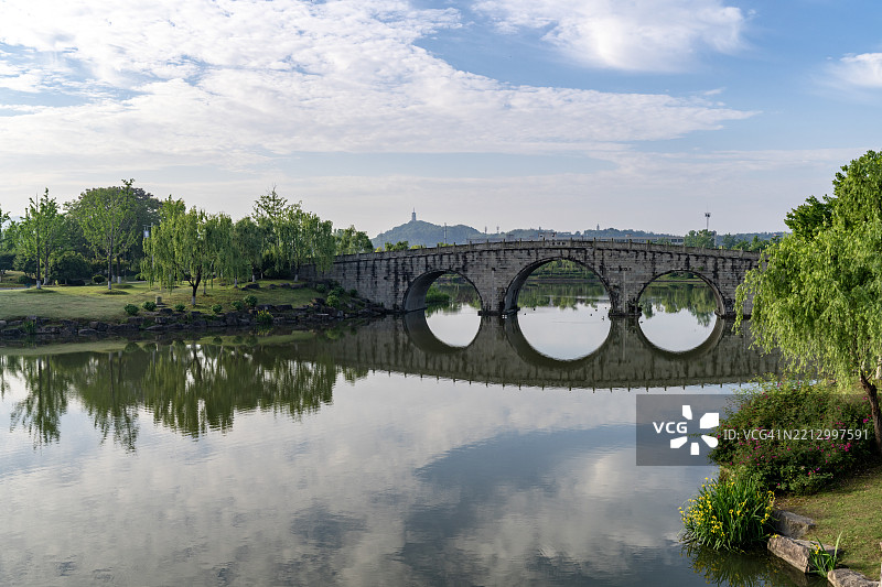 拱形石桥映照在宁静的湖面上图片素材