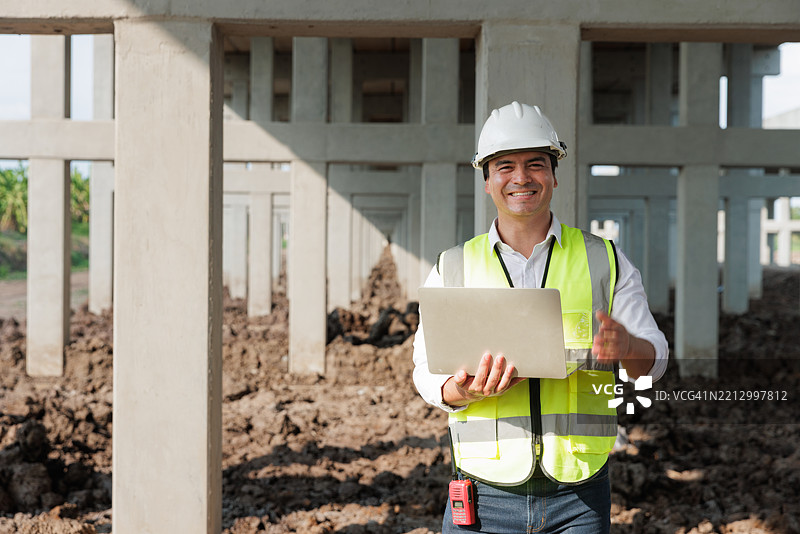 中年男性土木工程师在工地上使用笔记本电脑的肖像图片素材