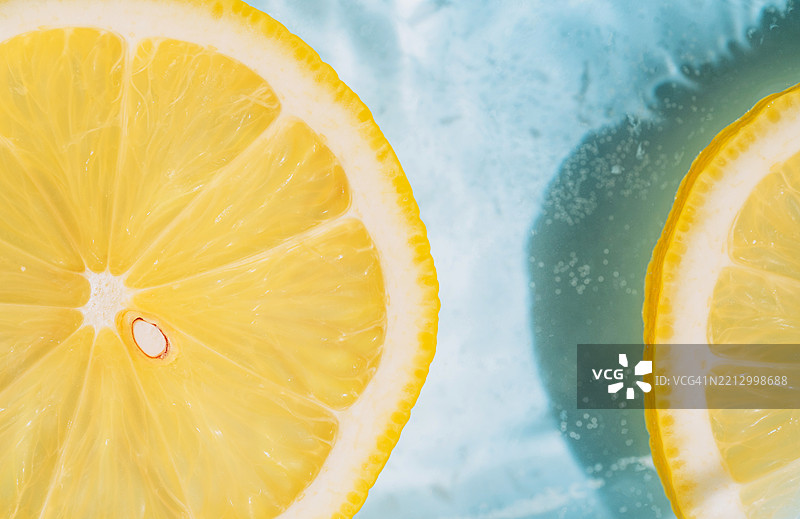 夏季背景，特写照片中的黄色柠檬在蓝色波浪水中图片素材