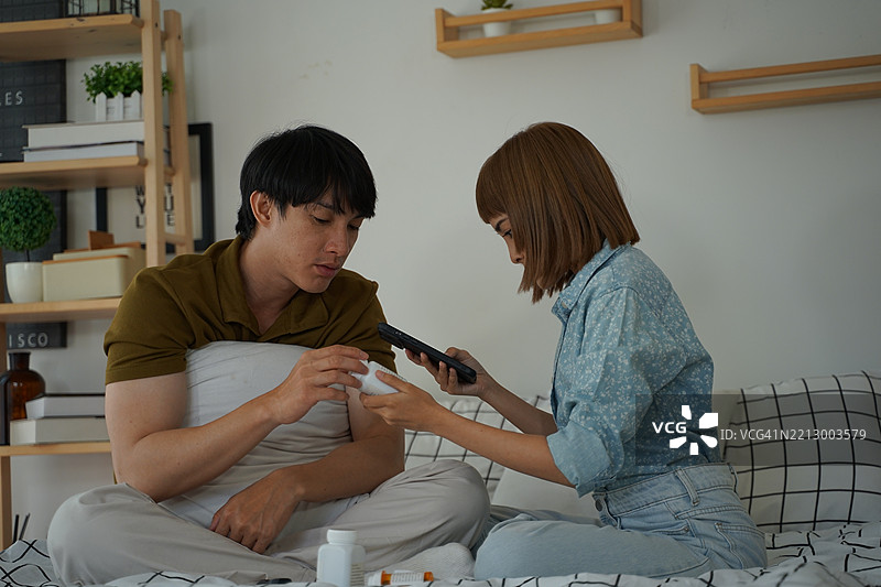 亚洲夫妇在家进行健康检查。图片素材