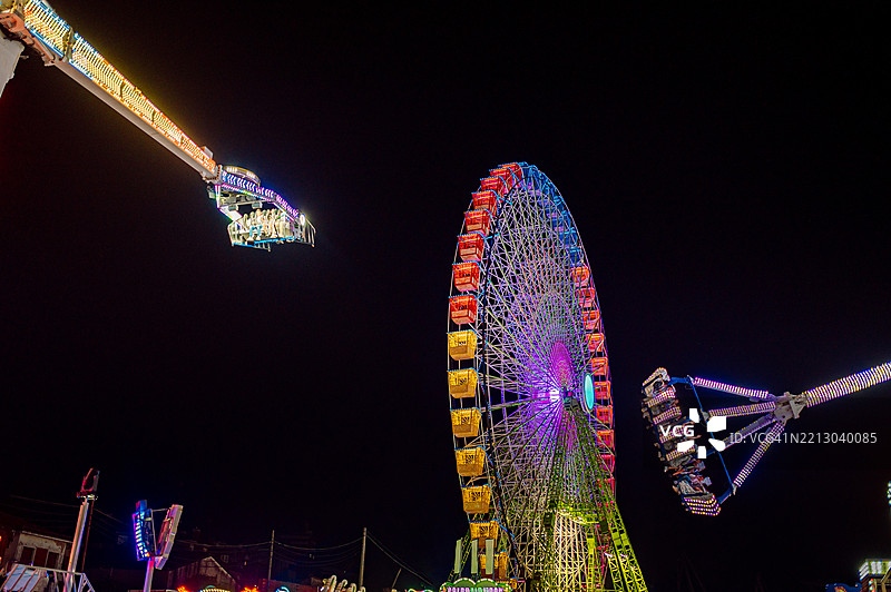 摩天轮和旋转木马在夜晚照亮游乐园图片素材