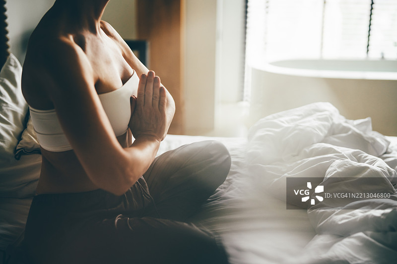 女人在家床上冥想。图片素材