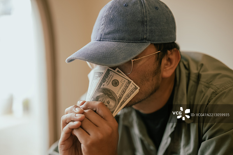 隐藏在美元钞票后面的诈骗者图片素材