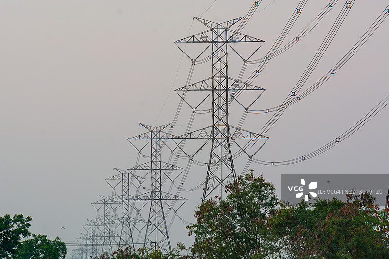 日落时分高压电塔矗立在宁静的风景中图片素材