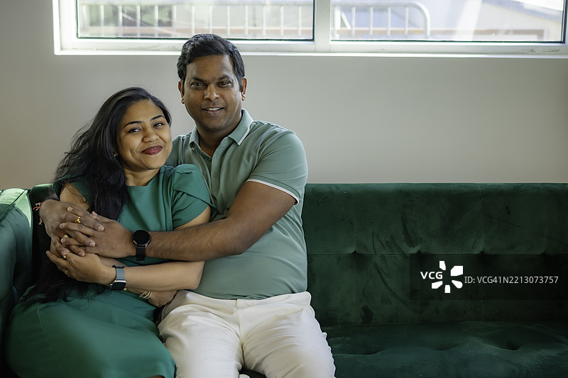 穿着得体的已婚印度夫妇在沙发上共度时光图片素材