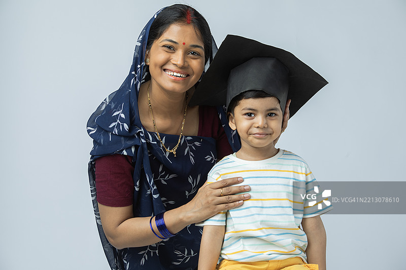 母亲和男孩在白色背景前看着镜头图片素材