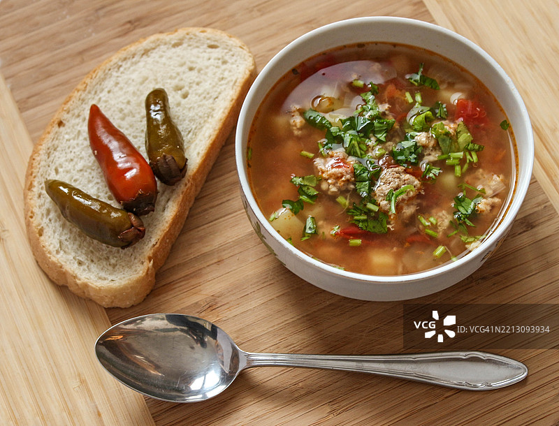 高角度视图的汤和面包放在木桌上 - 肉丸汤配辣椒图片素材