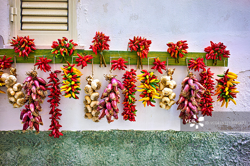 意大利普利亚大区维耶斯特，红辣椒、青葱和大蒜挂在房子外面晾干图片素材