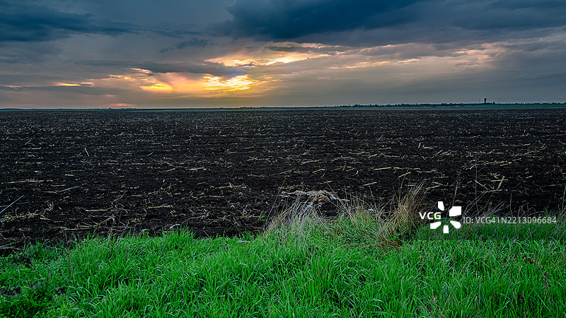 日落时分，天空映衬下的田野美景图片素材
