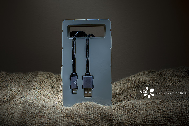 黑色USB电缆在布料背景上的塑料包装中，留白，乌克兰图片素材