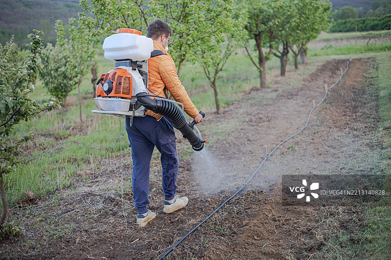 年轻农民背着喷雾器图片素材