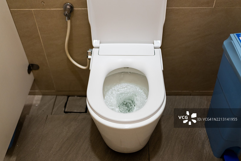 公共厕所正在冲水。图片素材