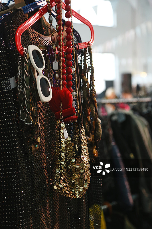 时尚服装的车库销售，亮片连衣裙和背心，亮片手袋，复古太阳镜和设计配饰，背景为跳蚤市场图片素材