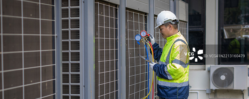 技术员正在检查空调。空调、暖通空调服务技术员使用仪表检查制冷剂并添加制冷剂。图片素材