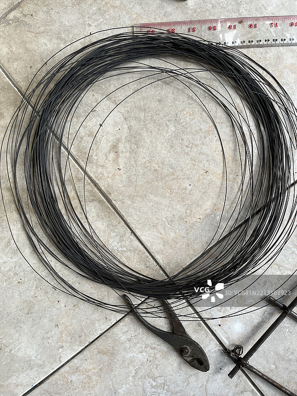 卷绕钢丝与钳子和尺子放在瓷砖地板上 - 建筑材料平铺展示图片素材