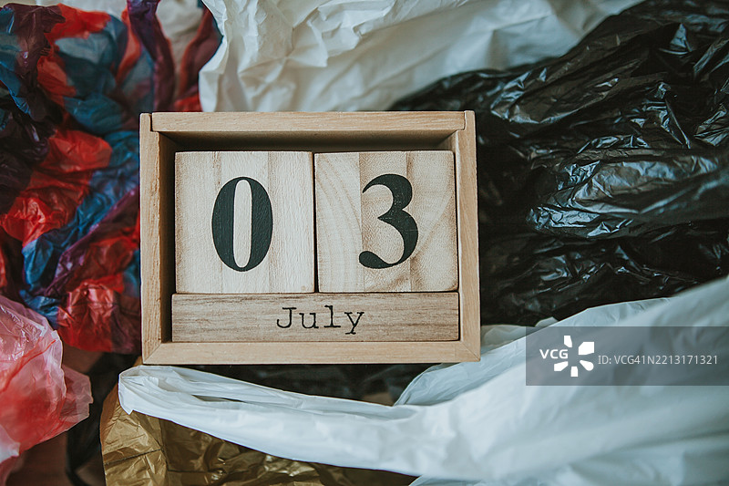 7月3日，木质日历块显示日期为7月3日，周围有塑料袋，国际无塑料袋日图片素材
