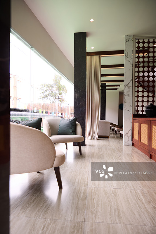 现代休息室室内，配有优雅的家具和大型窗户以获取自然光照图片素材
