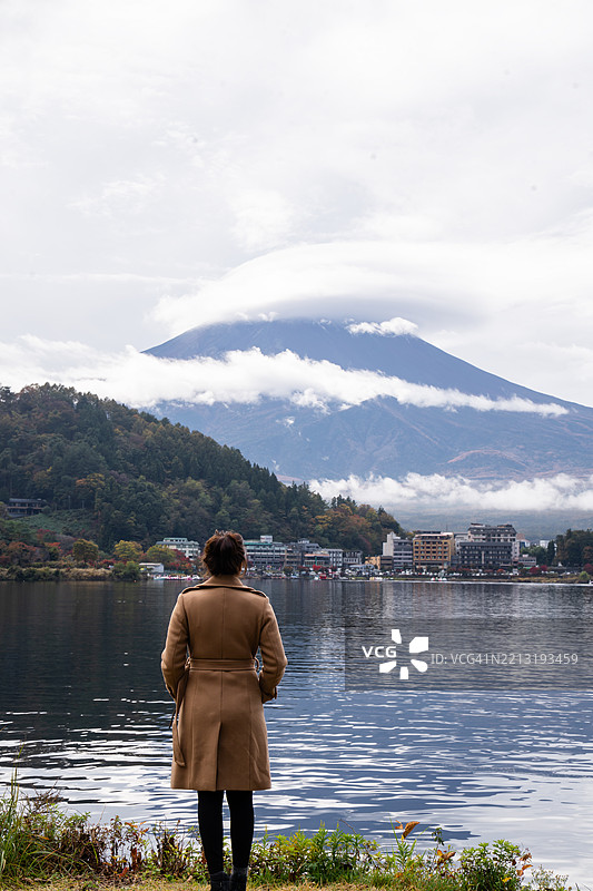 春天，女人在湖边欣赏美丽的富士山图片素材