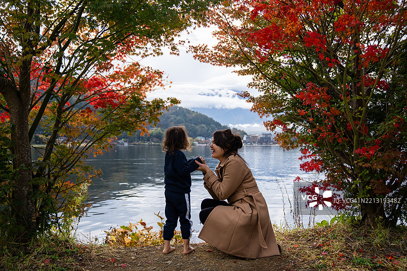亚洲家庭在春天的湖边欣赏美丽的富士山图片素材