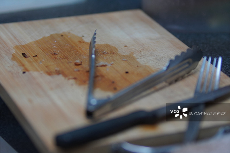 木质切菜板上的刀、夹子和叉子图片素材