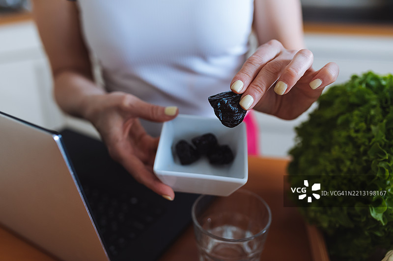 厨房环境中手握干梅子的特写图片素材