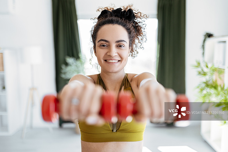 年轻女运动员专注于家庭力量训练图片素材