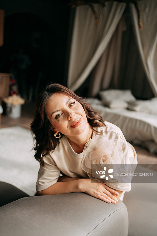 优雅的女性在波希米亚风格的房间里放松地坐在沙发上图片素材