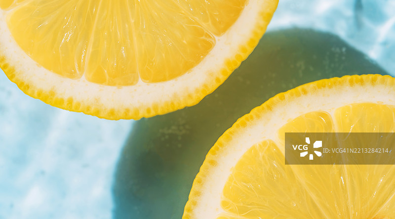 夏季背景，特写照片中的黄色柠檬在蓝色波浪水中图片素材