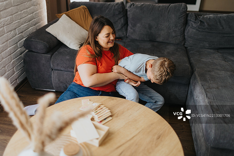 妈妈和儿子在家里玩多米诺骨牌图片素材