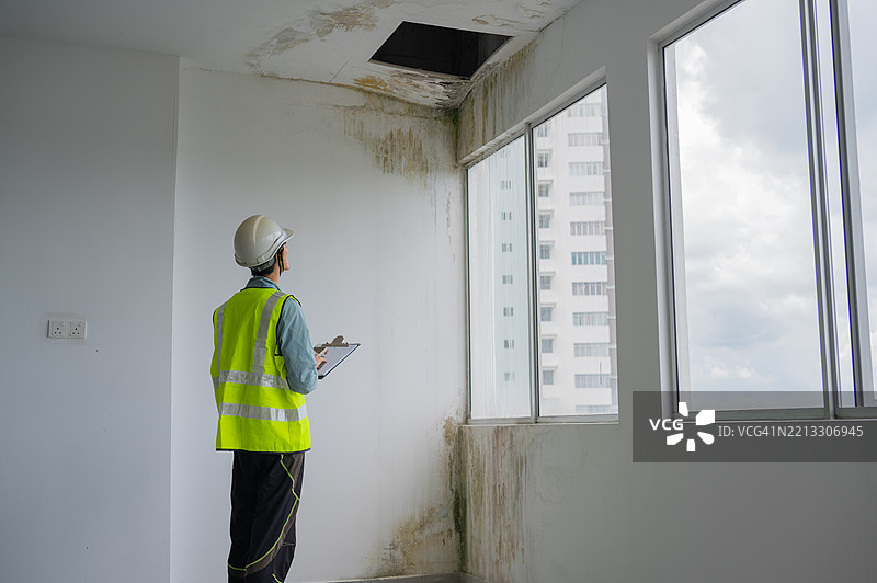 亚洲女性检查员手触摸漏水缺陷墙以检查是否有潮湿图片素材