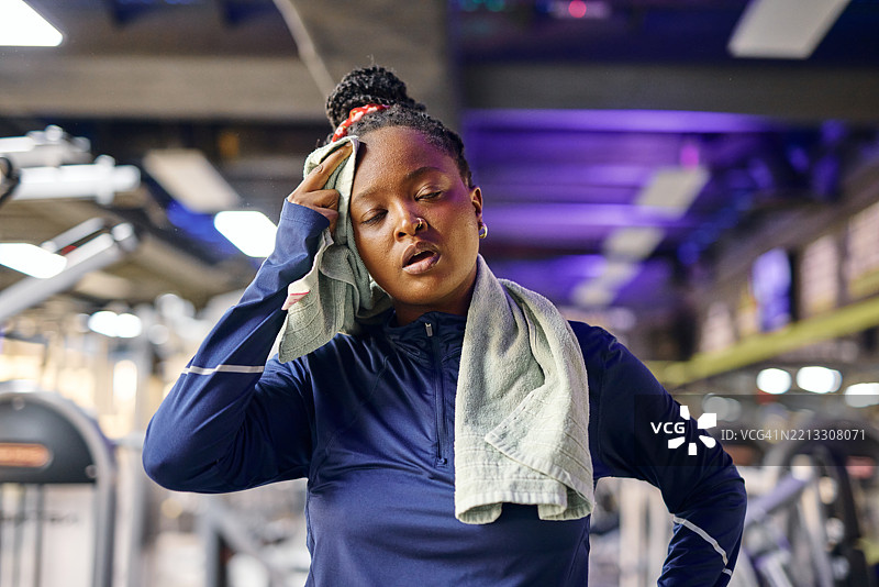 疲惫的运动员在健身房锻炼后擦汗图片素材