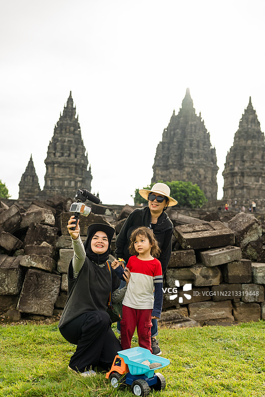 多代家庭在旅行中用相机和麦克风直播，讲解普兰巴南寺。图片素材