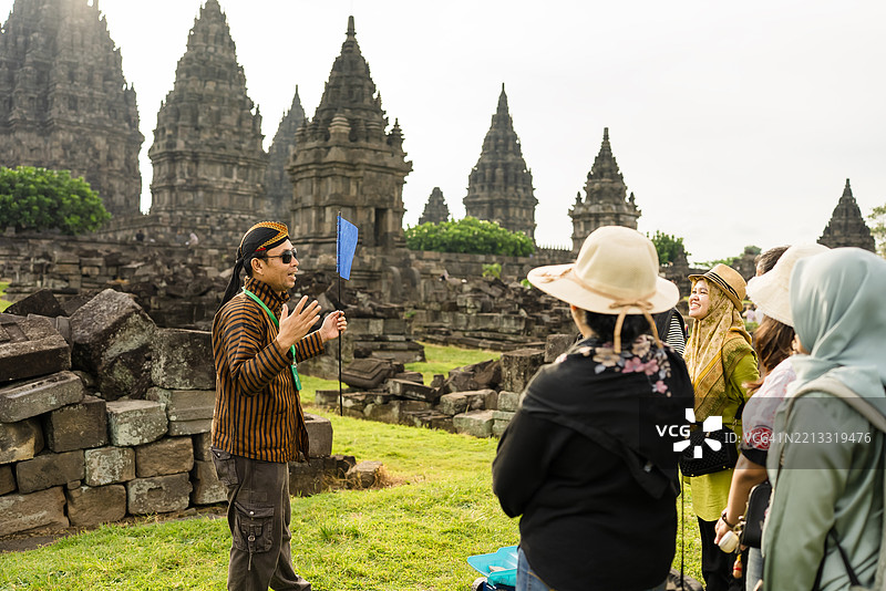成熟的导游向游客团展示并讲解普兰巴南寺。图片素材